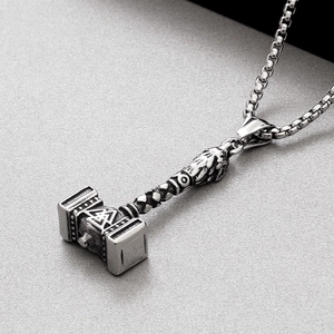 Detailed close-up of retro Viking Mjolnir pendant with intricate patterns on box chain