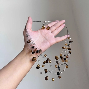 Handheld view of multi-layer tiger eye beaded necklace and matching earring set