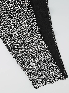 Macro shot of shimmering silver sequins densely sewn on black luxury evening dress fabric