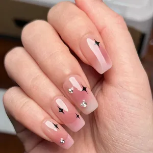 Detailansicht der rosa Ombre-Nagelsticker mit schwarzen Sternenmustern und kleinen Strasssteinen