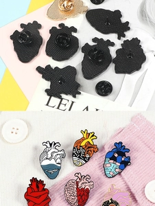 Detailed view of creative anatomical heart enamel pins with secure butterfly clasp closure