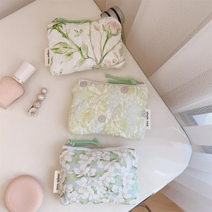 Detailed view of quilted cotton mini storage bags with floral patterns and zipper