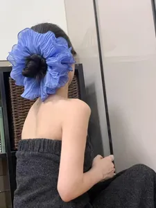 Close-up of a large pleated crystal blue hair scrunchie made from lightweight chiffon fabric
