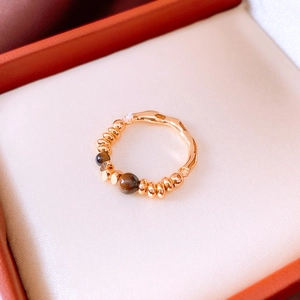 Macro detail of 18K gold plated ring featuring tiger eye beads on a red jewelry box