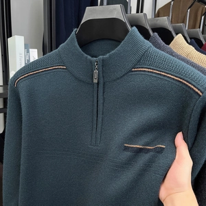 Detail of dark green knit sweater featuring gold shoulder stripes and half-zip high collar