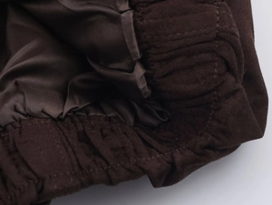 Makroaufnahme der dunkelbraunen Wildlederjacke mit Satinfutter und Rippstrickbündchen