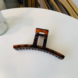 Detail view of large tortoiseshell claw clip with acetate finish on white table
