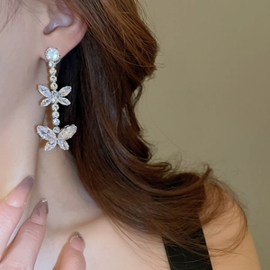 Detail of silver butterfly zircon tassel earrings on model showing elegant drape effect