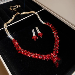 Macro shot of gold jewelry set with red marquise gems and zircons in a velvet box
