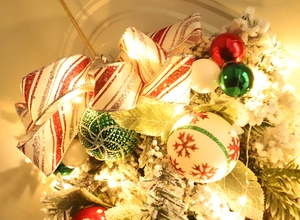 Detail of Christmas teardrop swag with LED lights, red bows, and patterned ornaments