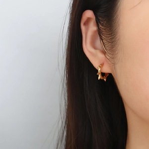 Fashionable punk gold stainless steel hoop earrings with rivets on a male model