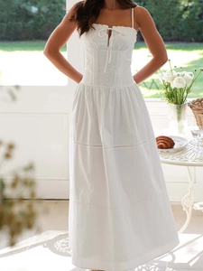 Detail view of white sundress with drawstring neckline and button bodice elements