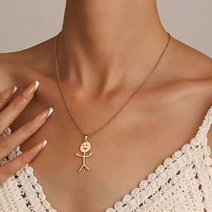 Detalle de cerca del collar dorado con colgante de monigote divertido y rebelde