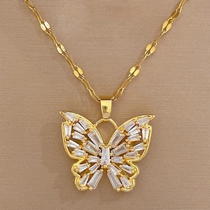 Detailed close-up of golden butterfly pendant with rectangular cubic zirconia stones