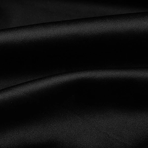 Macro shot of high-quality black satin fabric showing silky texture and elegant draping