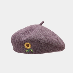 Detail of purple wool blend beret featuring intricate sunflower embroidery on soft fabric
