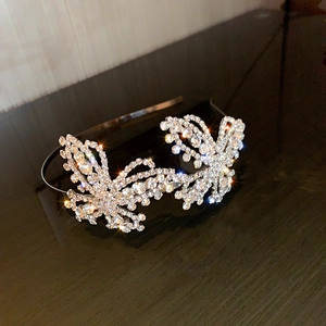 Close-up of sparkling rhinestone butterfly headband with detailed silver metal frame