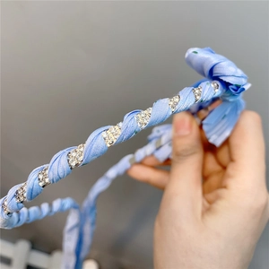 Elegant light blue braided fabric headband with sparkling rhinestones and floral details