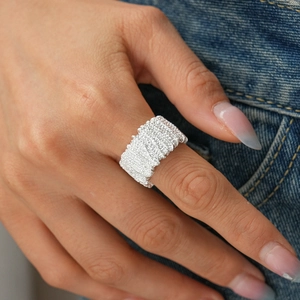 Detailed view of silver chunky ring featuring irregular hammered texture on model