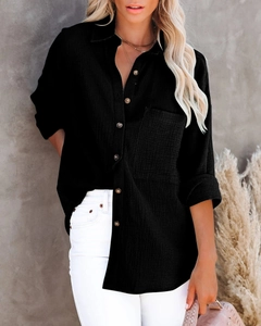Detail of black cotton linen shirt featuring natural wood buttons and textured fabric