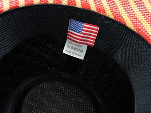 Nahaufnahme des 100% Papier-Materialetiketts und der US-Flagge im Strohhut