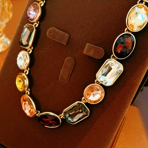 Dettaglio della collana vintage dorata con pietre preziose rettangolari e ovali colorate