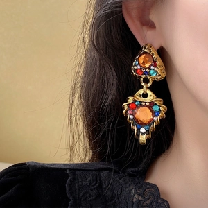Vintage baroque triangular drop earring with amber gemstone and pearls worn by a model