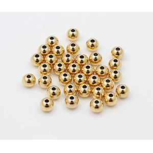 Macro detail of high-quality 18K gold-plated stainless steel round beads for jewelry making
