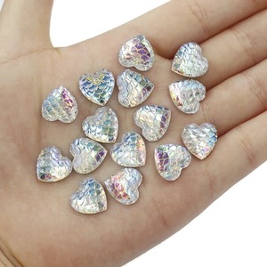Macro detail of 12mm resin heart charms with iridescent mermaid fish scale texture