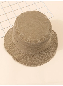 Gros plan d'un chapeau bob kaki montrant la texture sergée et les œillets en métal