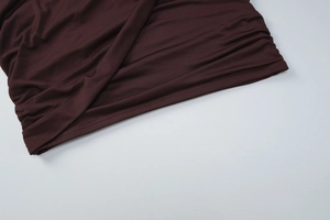 Detail of dark brown fabric showing precision stitching and pleated texture on women's set