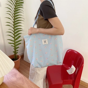 Blue checkered canvas tote bag with pink bow pattern and LOVE patch shown on shoulder