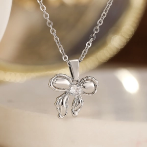 Elegant 18K gold-plated bow necklace with a clear zircon pendant on a silver chain