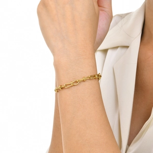 Detailed macro of gold plated Figaro link chain bracelet with U-shaped links and ball accents
