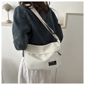 Detailed back view of model wearing white nylon crossbody bag with adjustable strap