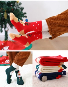 Detailed close-up of thick Christmas socks with festive elk and Santa Claus patterns