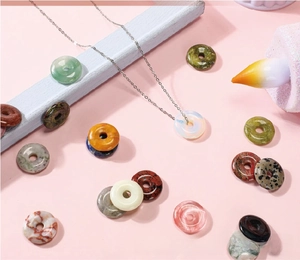 Detailed macro view of varied natural crystal donut pendants with silver chain necklaces