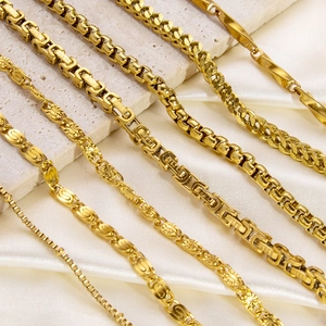 Variety of 18K gold plated titanium steel necklaces displayed on silk and stone