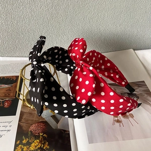 Haarreifen mit Polka-Dot-Schleife in Schwarz und Rot auf einem stilvollen Metallständer