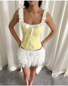 Detail of yellow gingham corset top with delicate lace trim and central bow detail