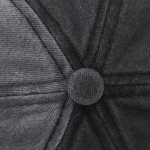 Detailed close-up of dark grey washed cotton baseball cap crown with stitched top button