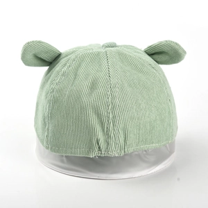 Détail d'un bonnet bébé en velours côtelé vert clair avec de jolies oreilles d'animaux