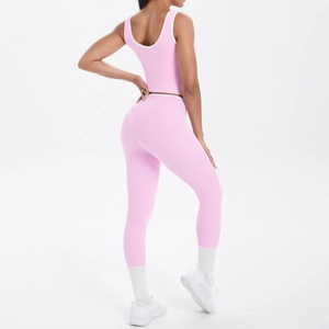 Pink two-piece yoga set with crop top and high waist leggings with white piping