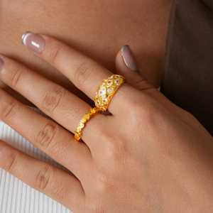 Detail view of 24k gold-plated grid rings set with sparkling zircons on finger
