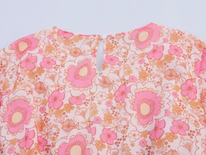 Dettaglio dello scollo posteriore dell'abito in chiffon floreale con bottone e goccia