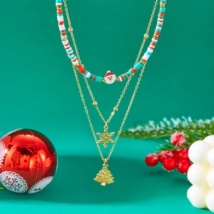 Three-layer Christmas necklace with Santa and tree pendants on a festive green background