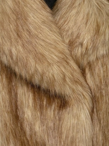 Macro shot showing high-density faux fur texture and camel brown gradient on short coat
