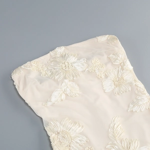 Macro detail of 3D floral embroidery on ivory mesh fabric for mermaid evening dress