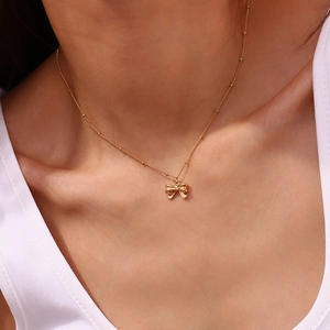 Elegance 18K gold plated stainless steel bow necklace on female model neck