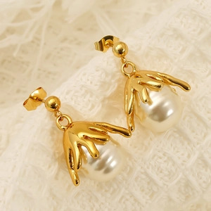 Vintage gold irregular fluid flower earrings with white pearls for women on white fabric